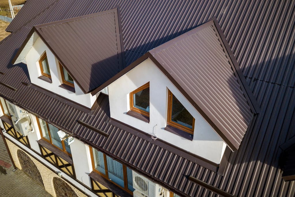 brown metal roof on a home with white siding