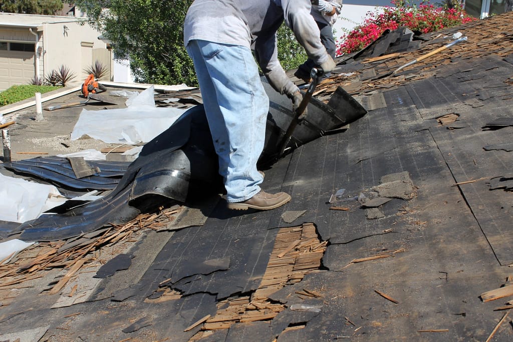 worker showing how to remove shingles