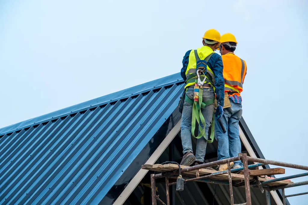 two roofer inspecting a metal roof