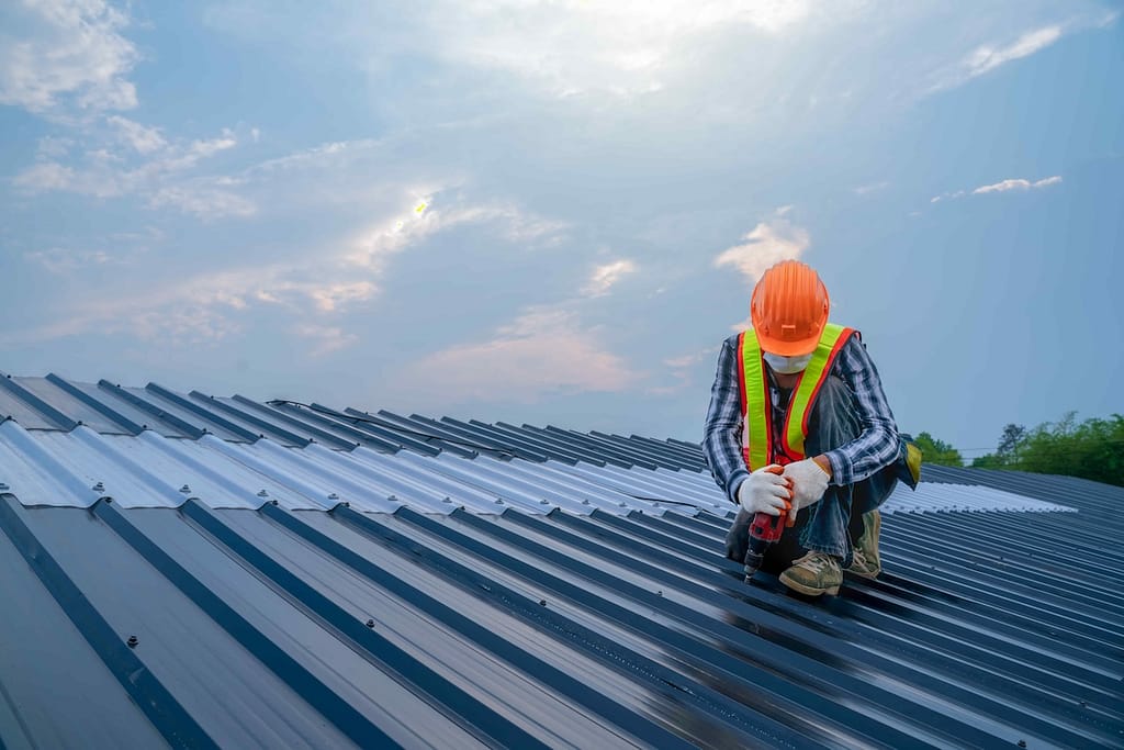 worker installing metal roofing commercial building malvern pa