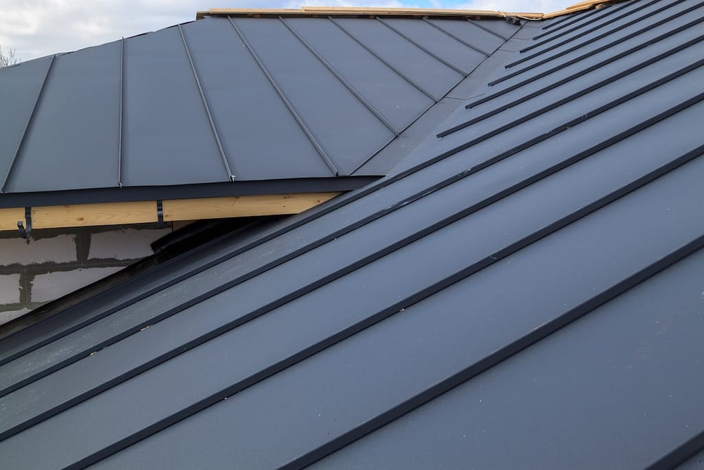 close up view of house under construction with black metal roof