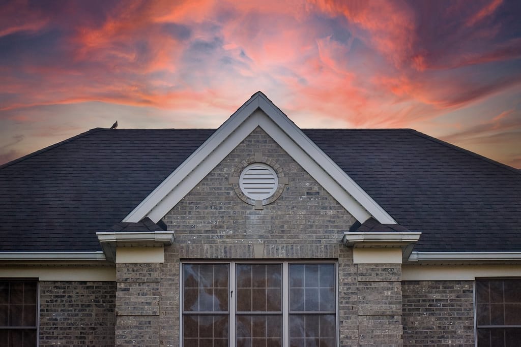 Large brick house with black shingle roof
