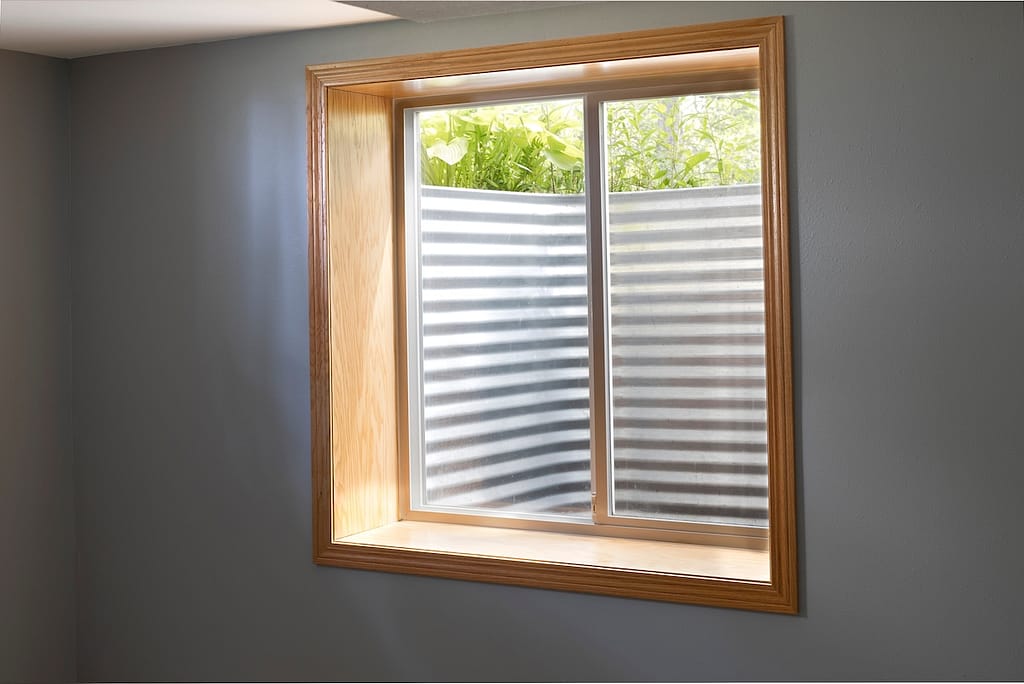 Egress window system installed in the basement. Basement bedroom with an egress window.