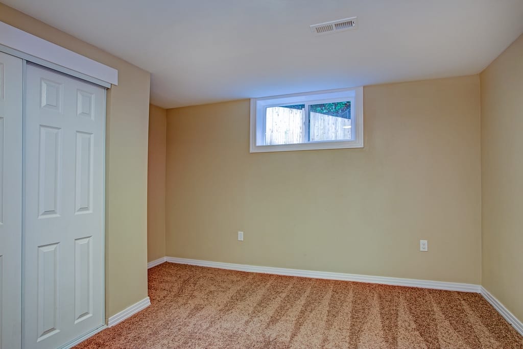 Empty room with white doors closet, sand beige walls, carpet floor in a luxury home.