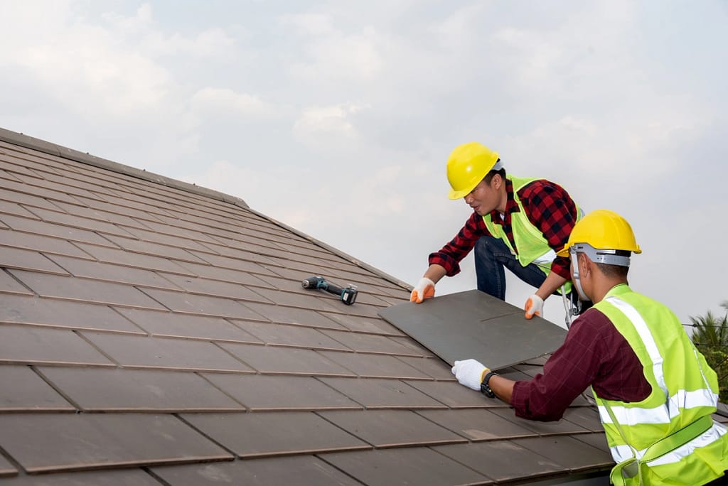 two worker installing new roof on for a family house