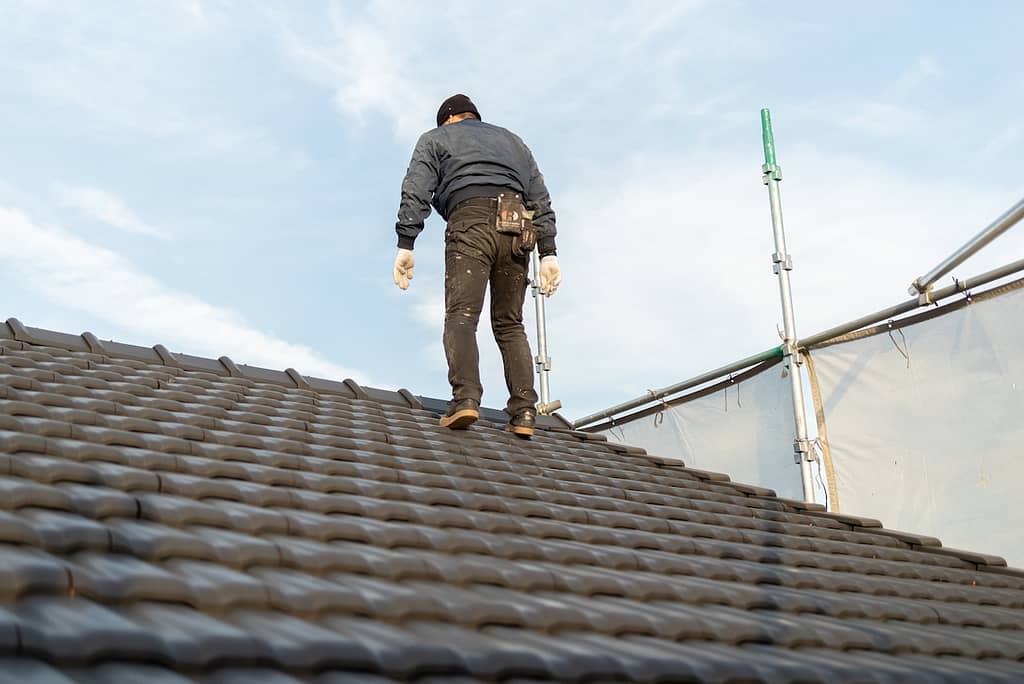 A roofer working on a tile roof