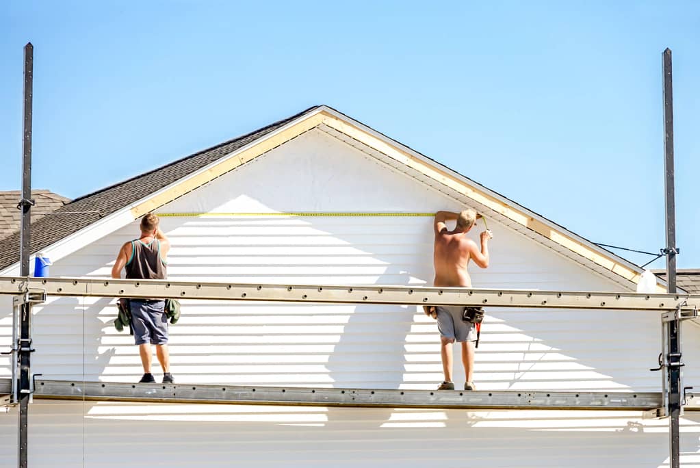 contractors show how to measure wall before cutting vinyl siding