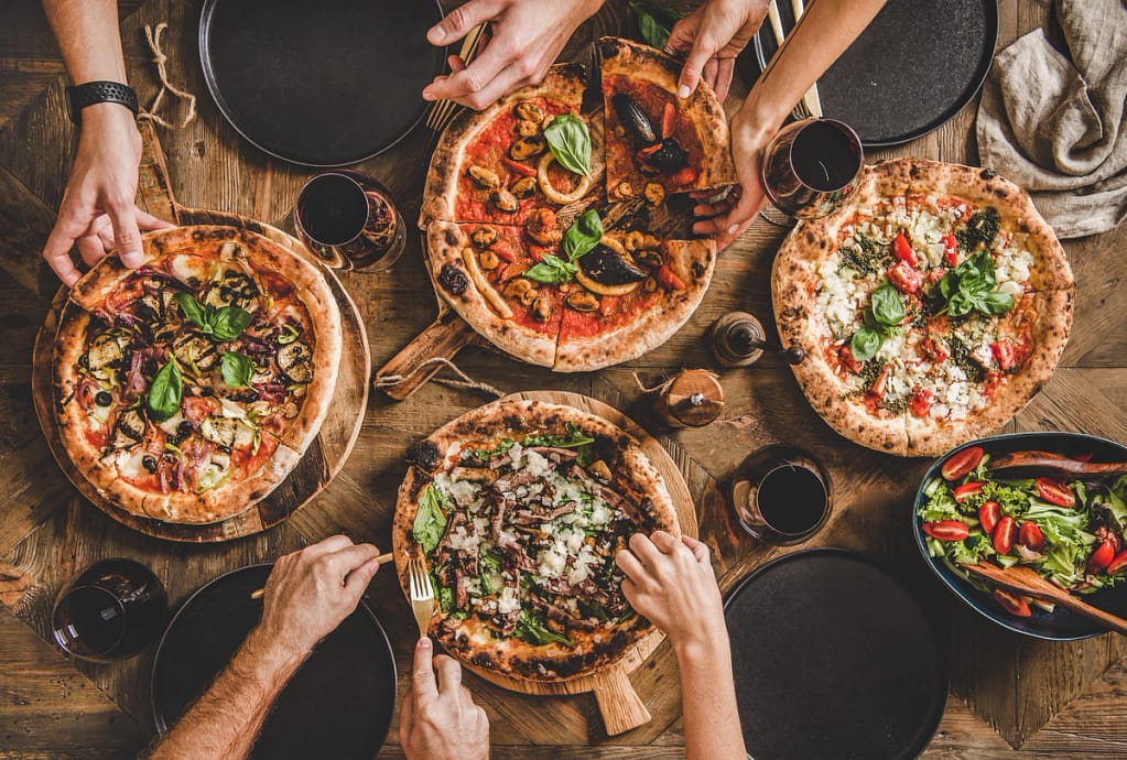 table full of various pizzas at a restaurant