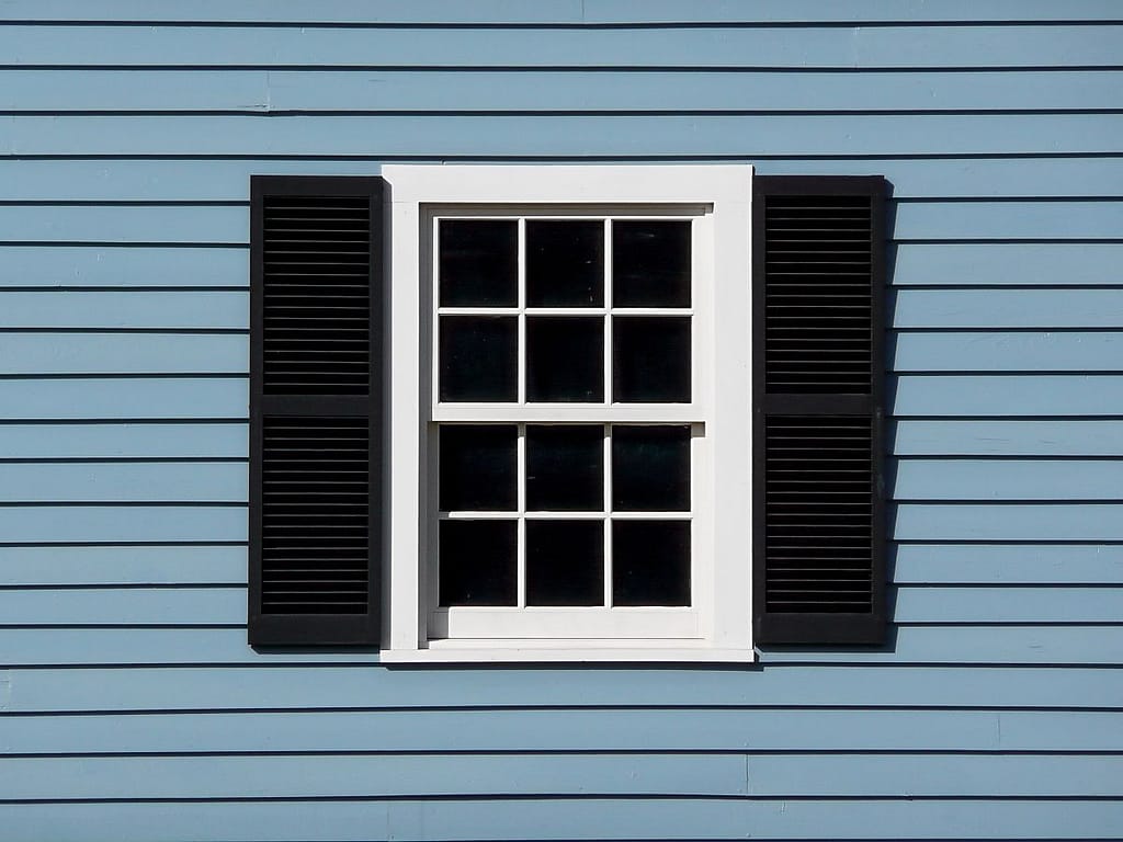 blue house with white window and black accents