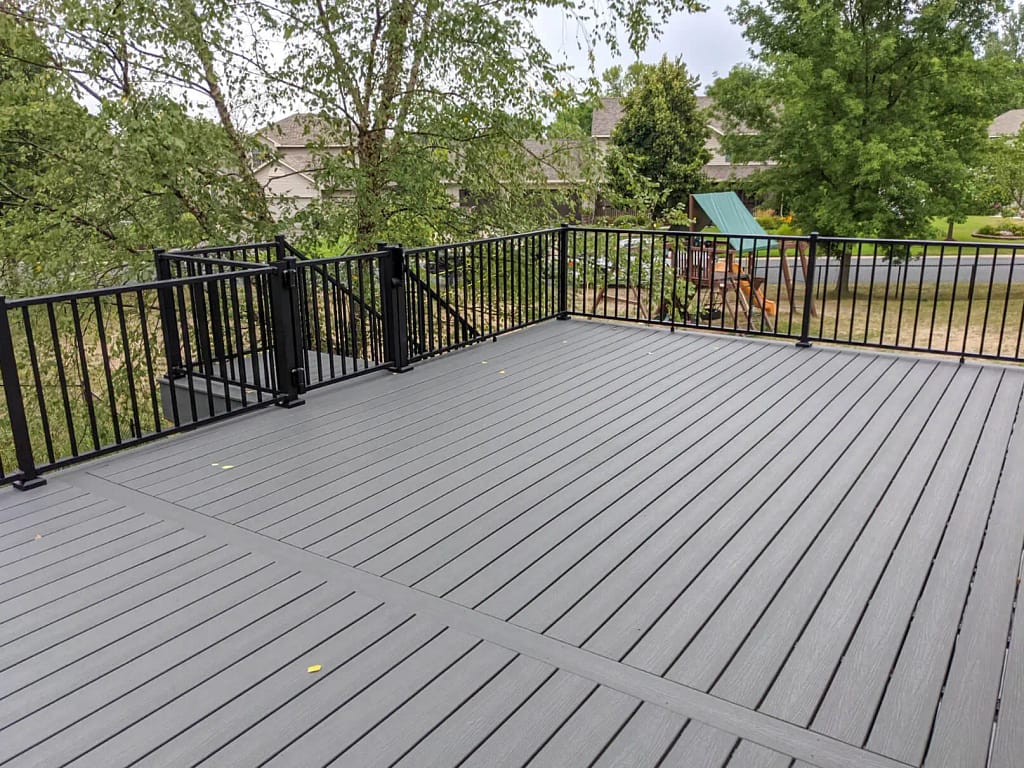 Custom built Trex Deck built with Clam Shell Trex Decking over looking green trees.