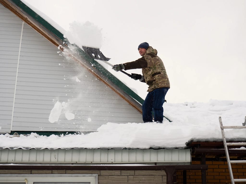 shoveling snow off of a roof
