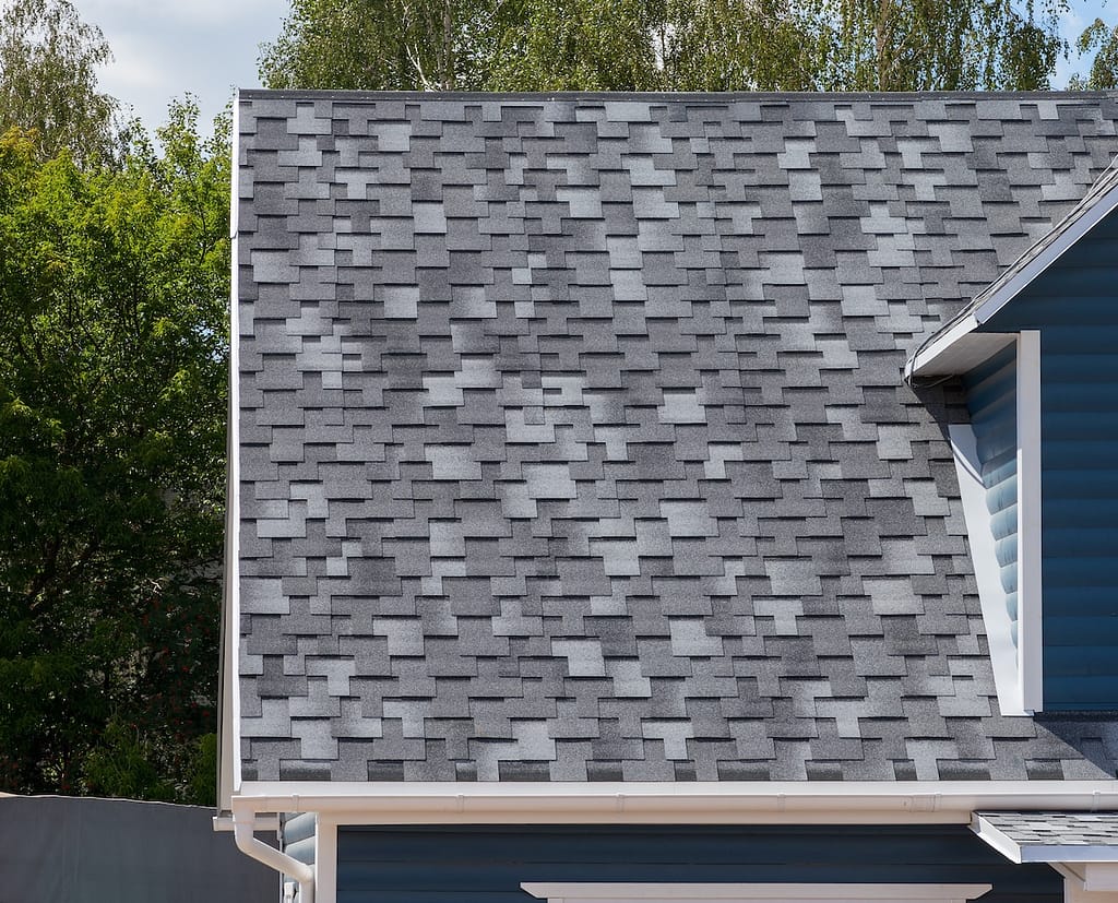 The roof of the house lined with gray dimensional shingles