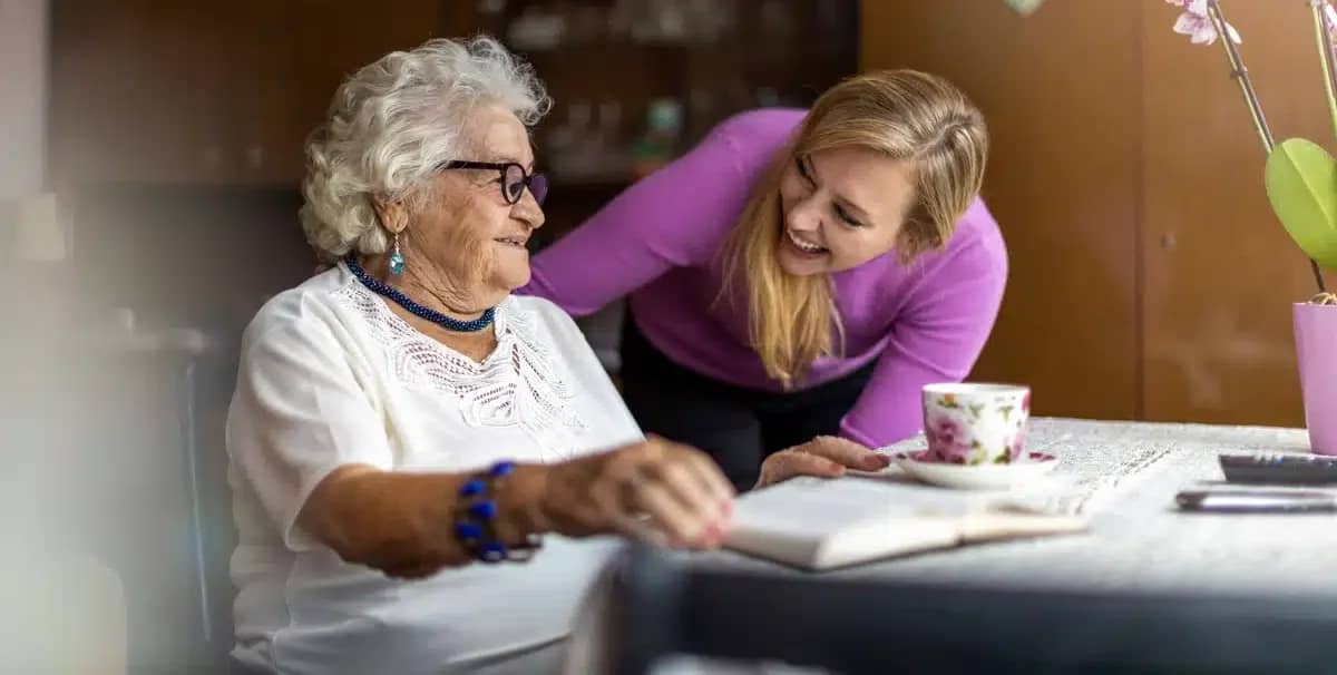 what does assisted living provide example - assisting elderly woman at the table