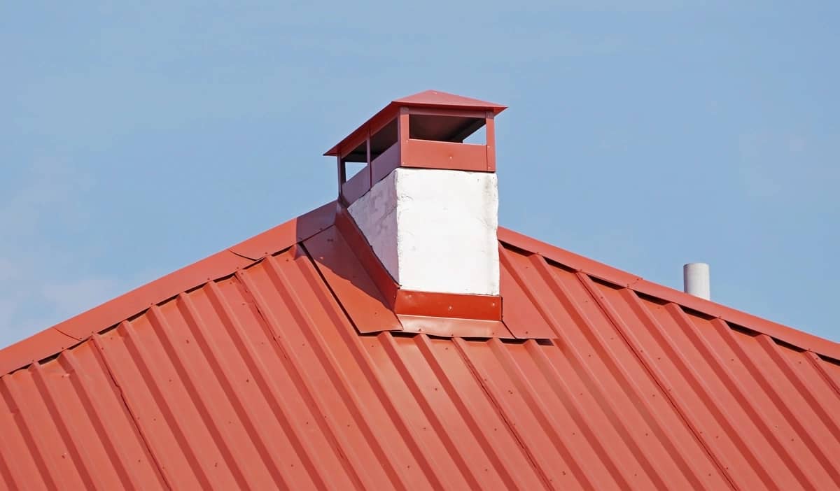 close up to red metal roof and chimney flashing
