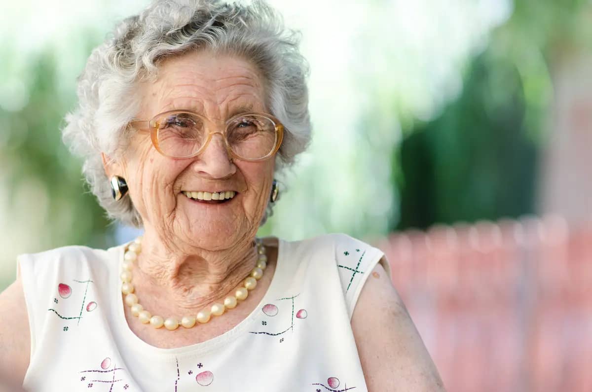 older woman with pearls and glasses