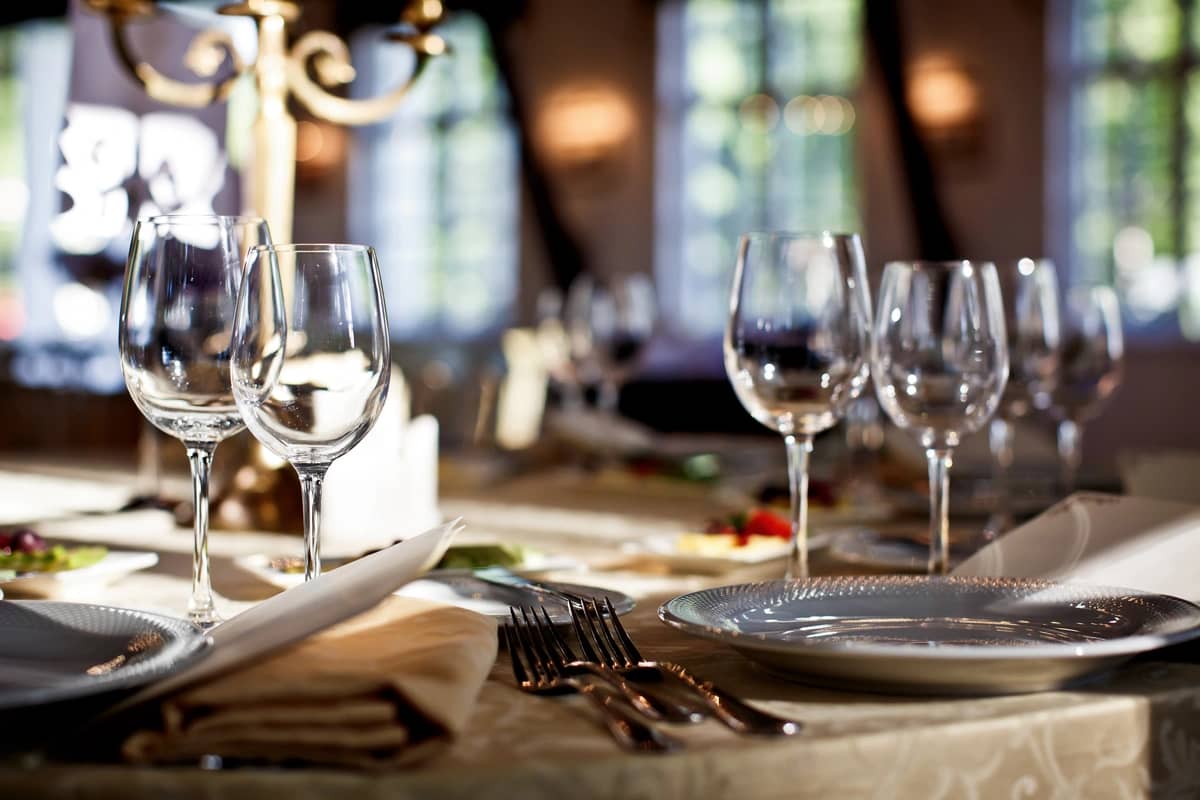 close up to restaurant table with service plates and wine glasses