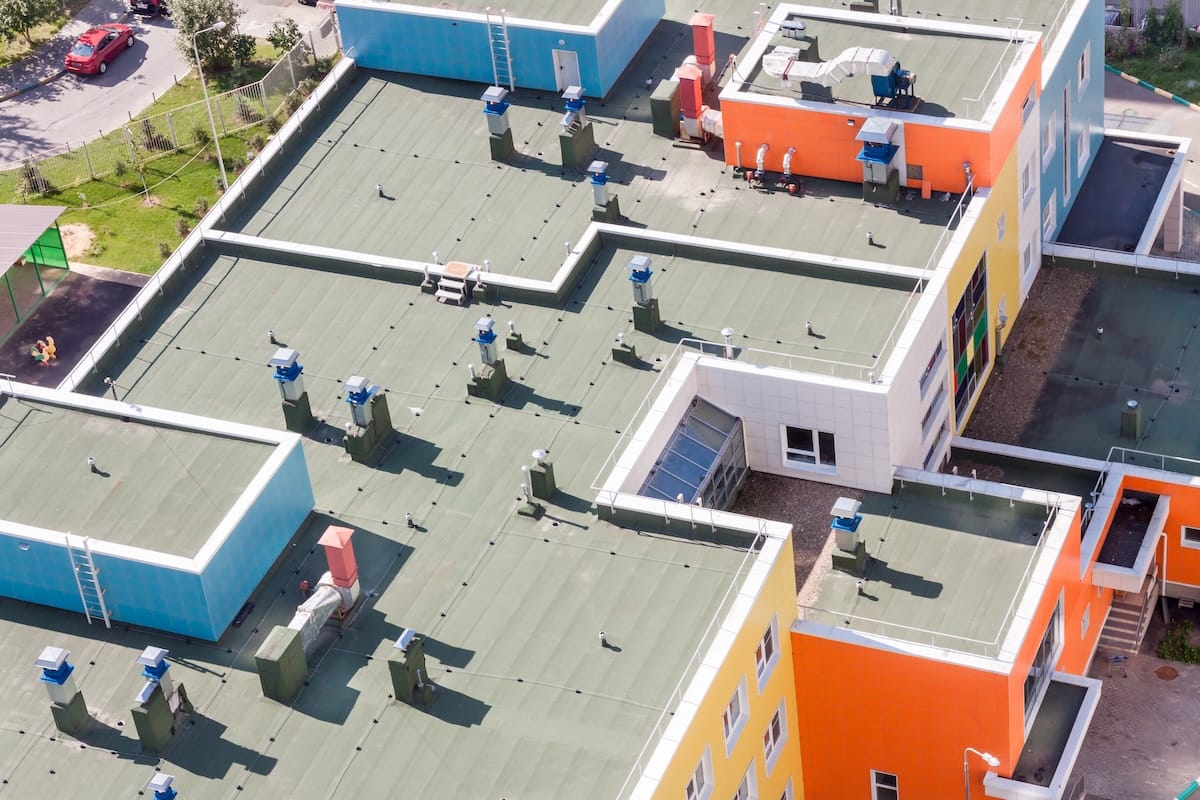 Aerial view of a colorful building with a green flat roof