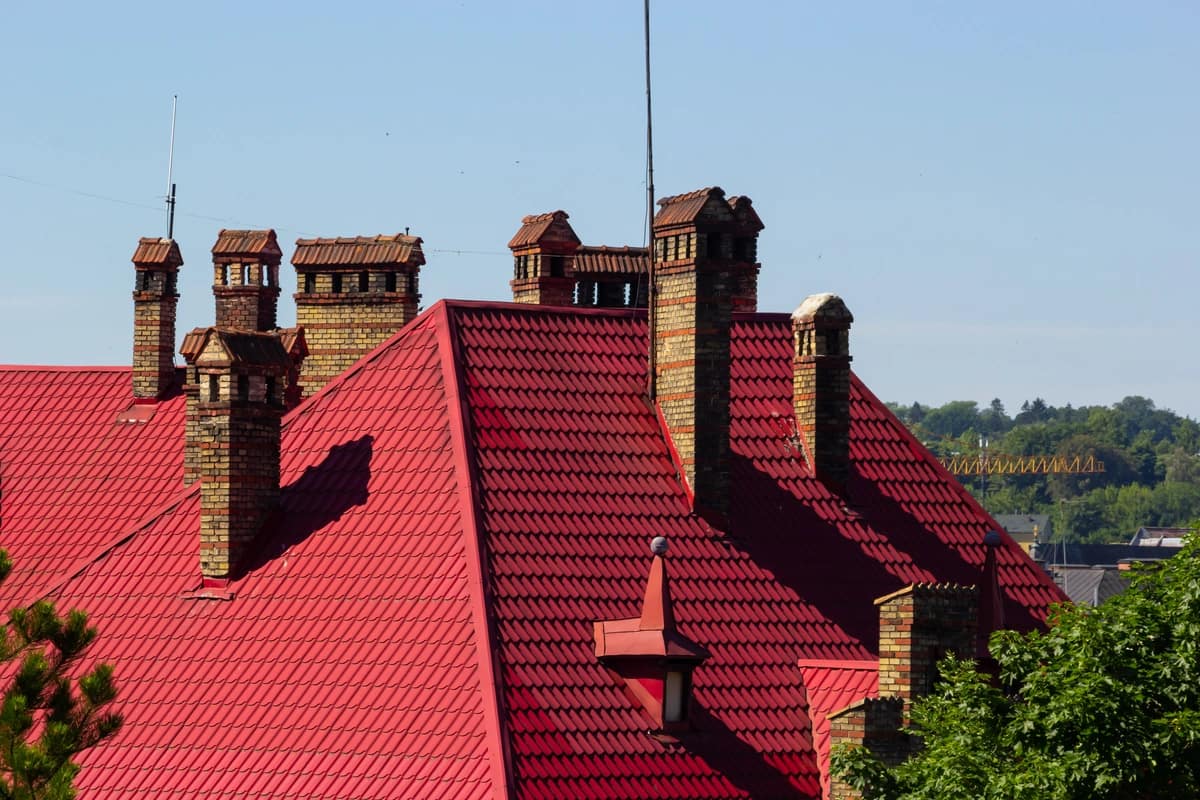 red tile large roof with multiple chimneys