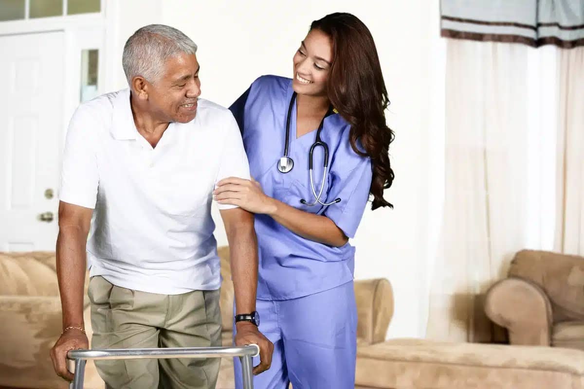 caregiver helping elderly man to walk