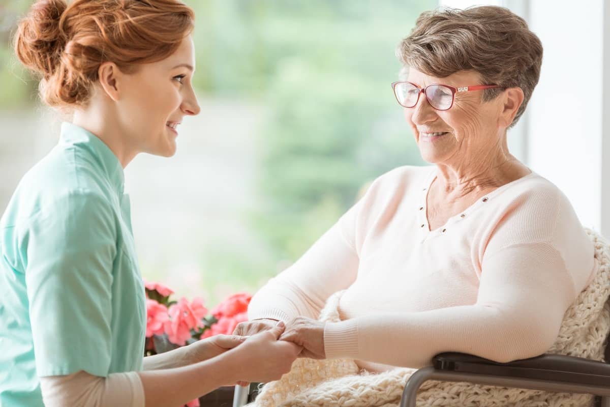 a nurse showing a gesture of care towards a old woman