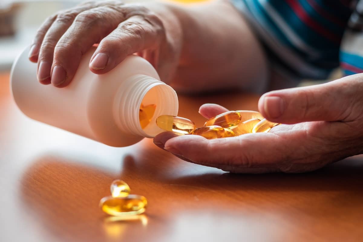 Senior woman pouring her multivitamins into her hand