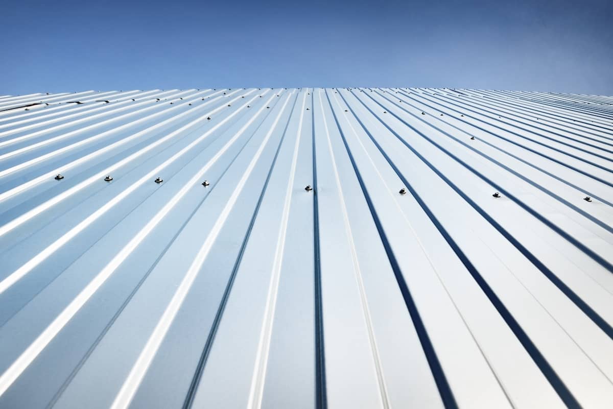 Close-up view of silver metal roof panels with evenly spaced screws