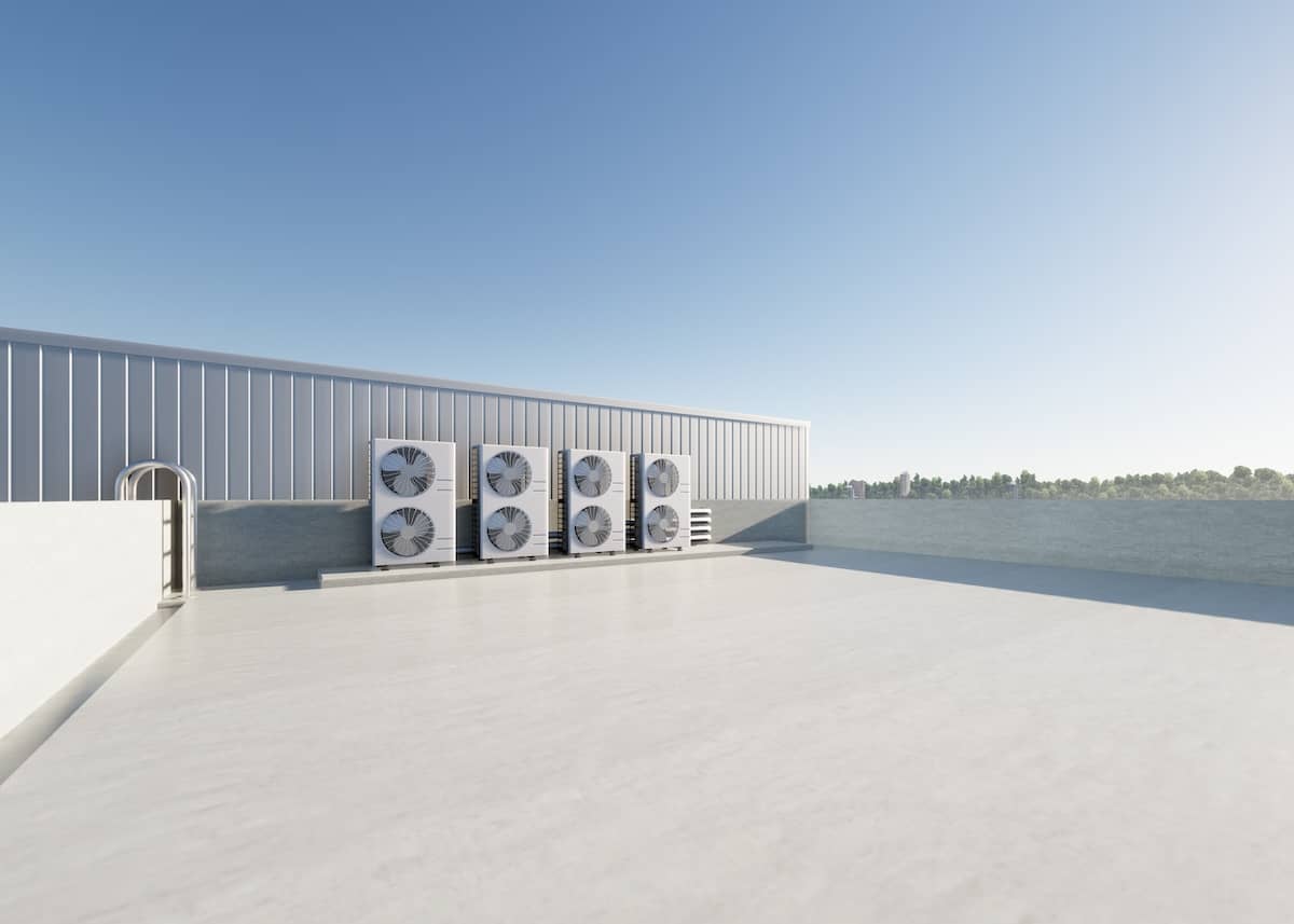 TPO Rooftop with large HVAC units against a metal wall, under a clear blue sky