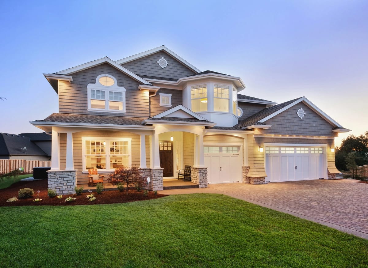 storm damage repaired house with a green lawn and ambient outdoor lighting