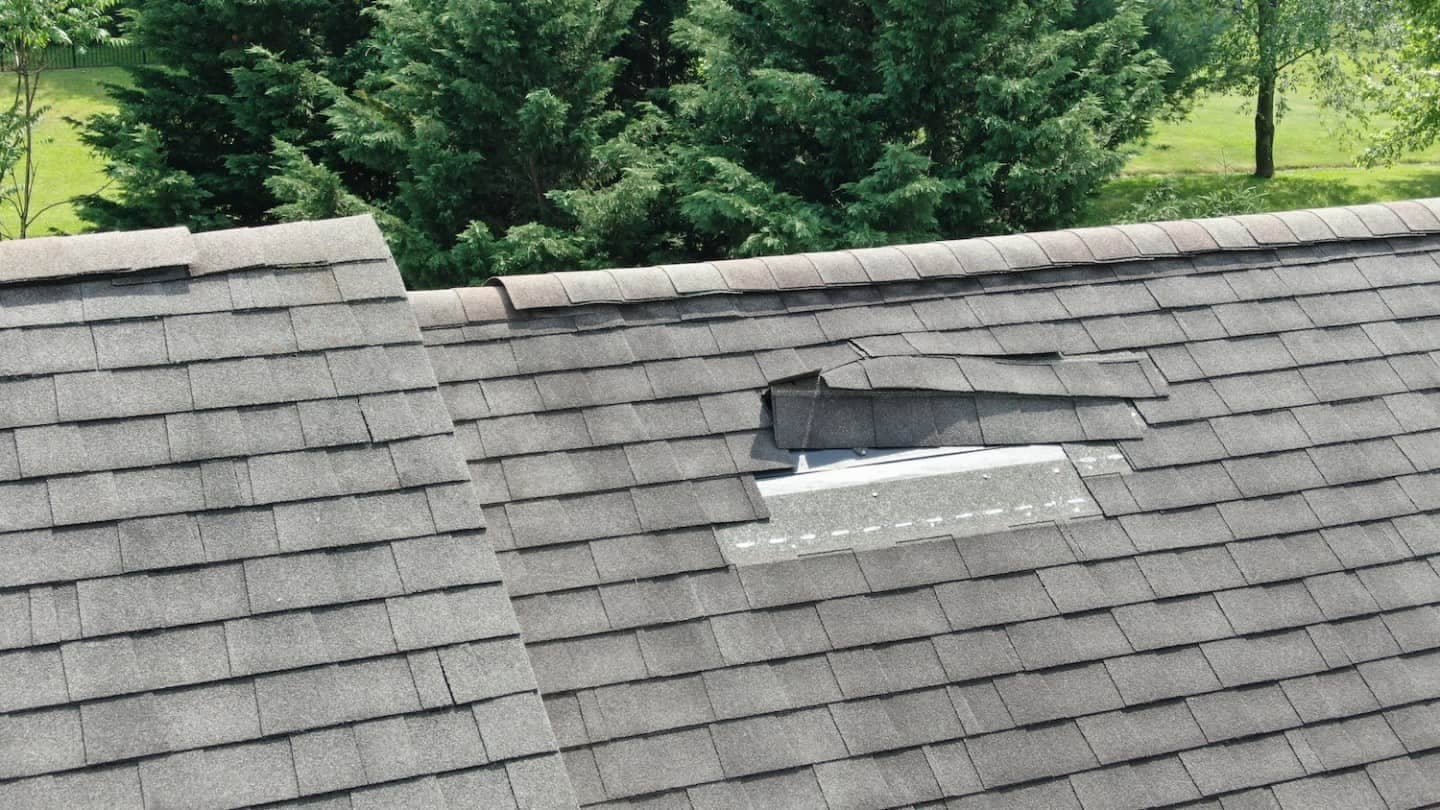 roof storm damage with loose shingles