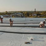 3 men performing commercial roof repair