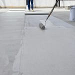 contractor covers flat roof with coating