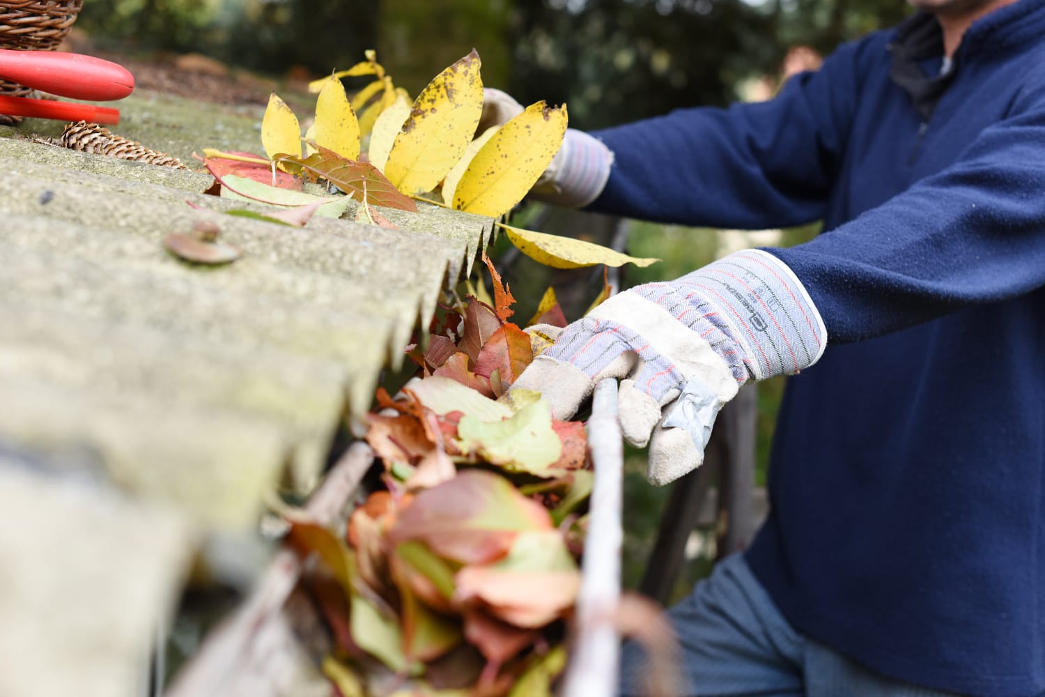 a worker is cleaning a clogged gutter