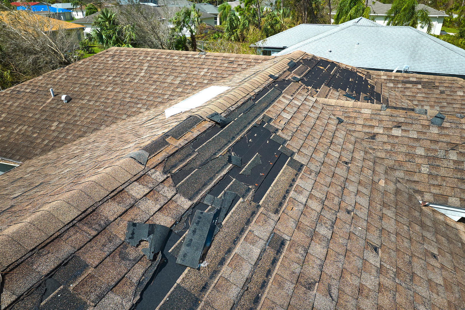 wind damage to roof-missing shingles from brown shingle roofing
