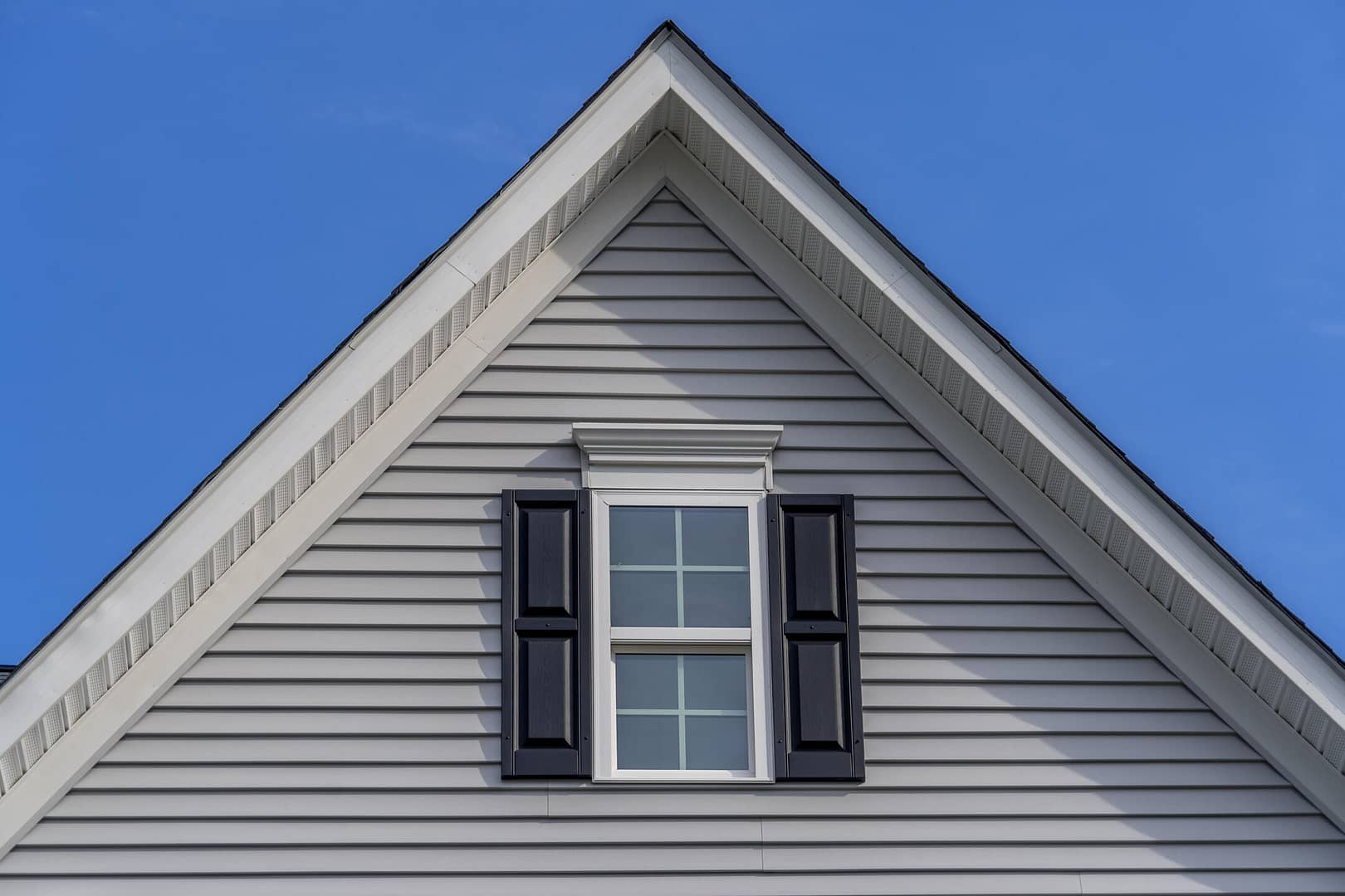 pitched roof-gable roof on a white sided house