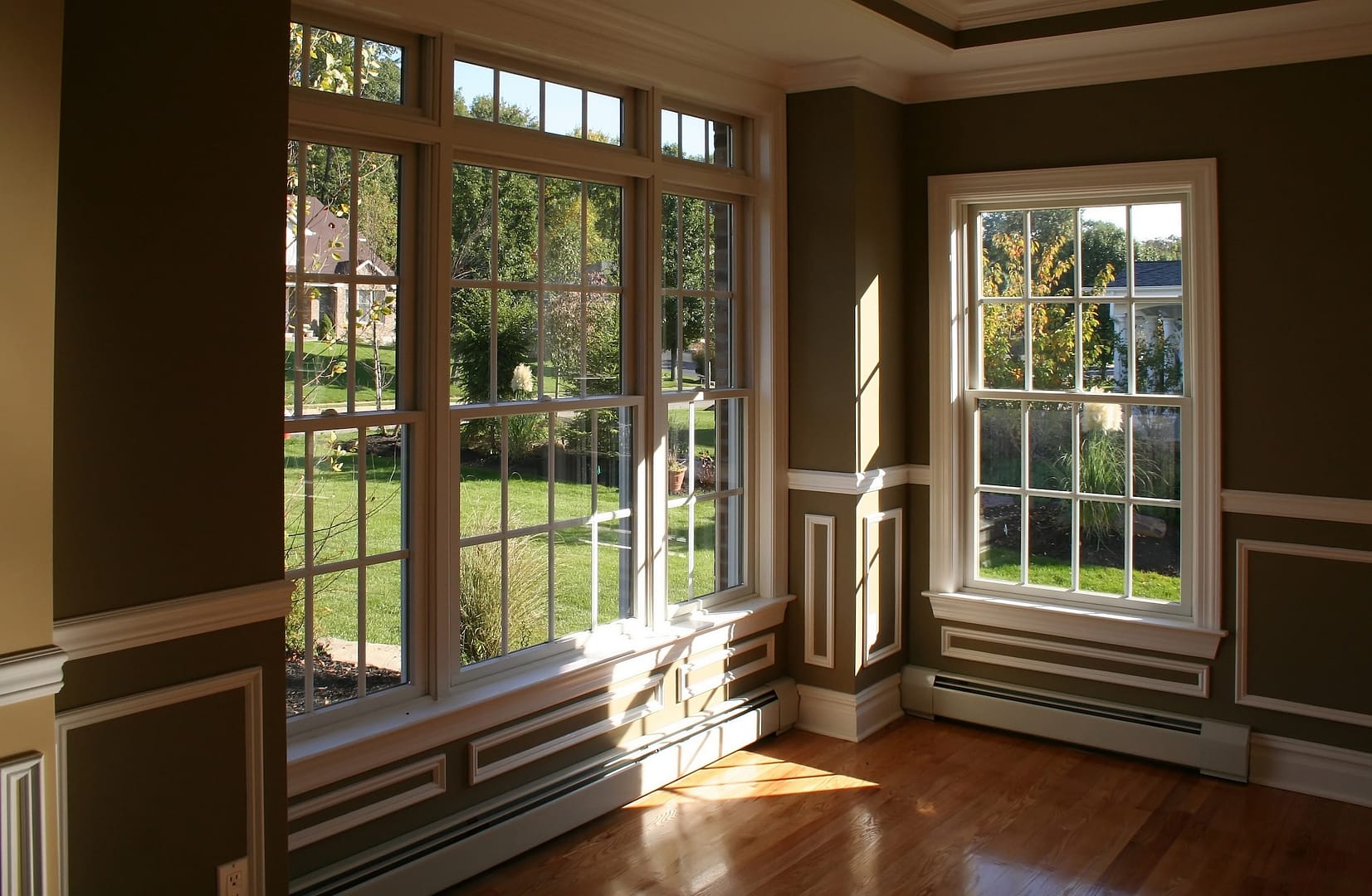 Sunny corner in living room with garden view through beautiful windows