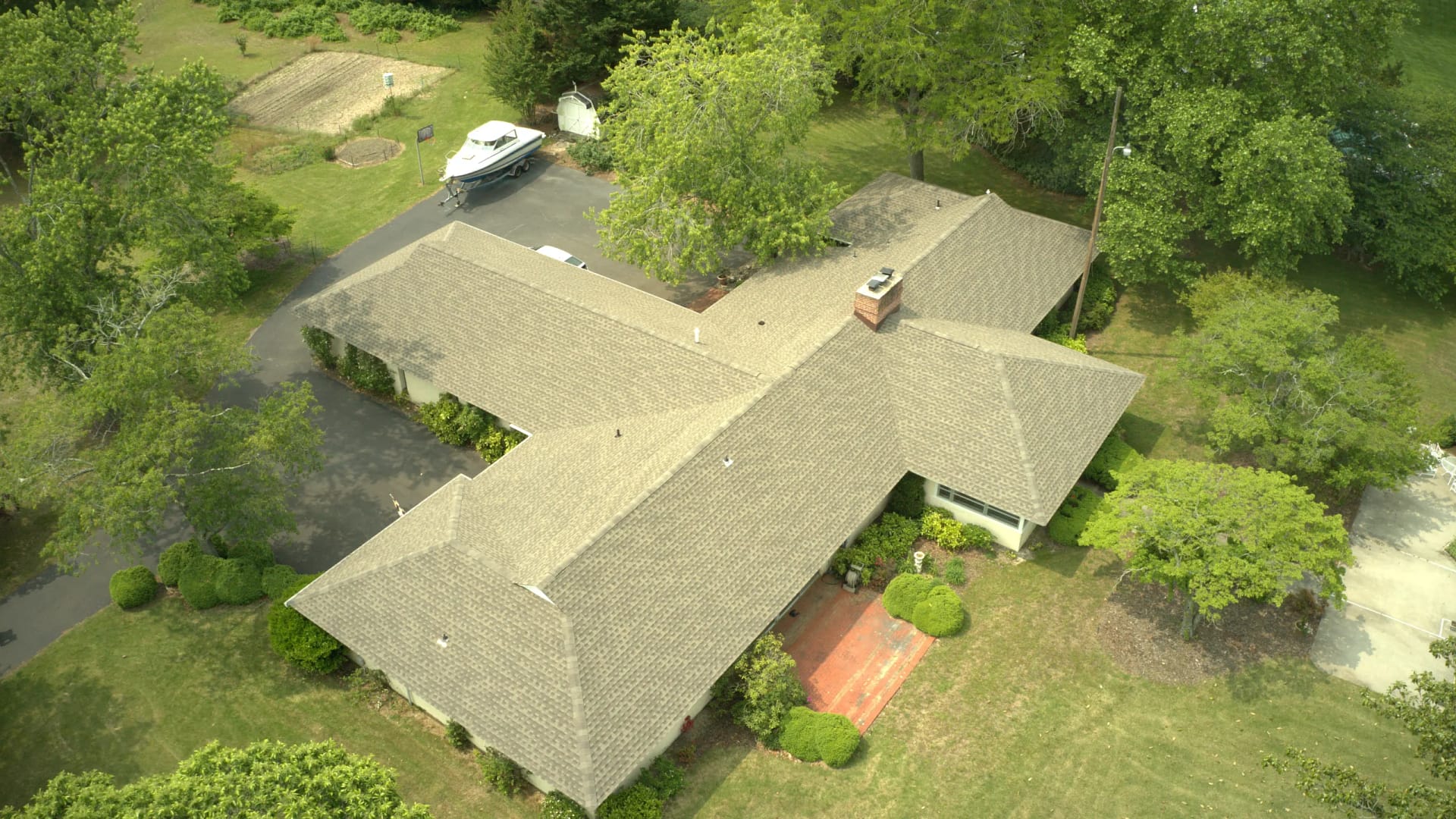downward view of new shingle roof installation on residential home in the woods