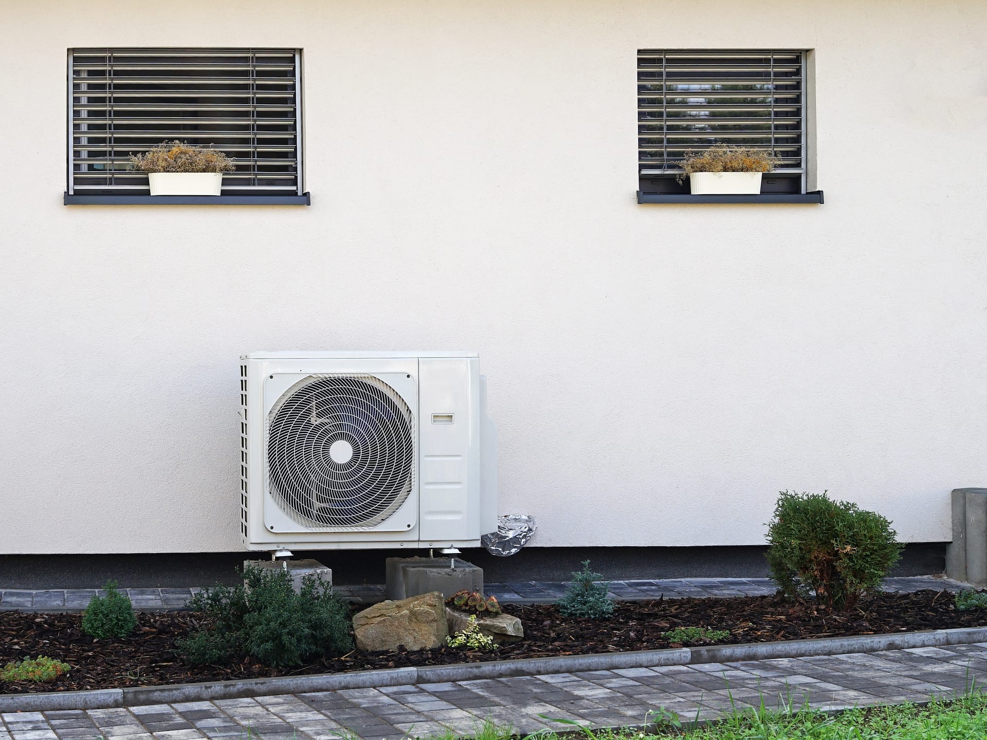 Heat pump or air conditioning outdoor unit in modern house of future using green electric energy, heat pump - efficient source of heat