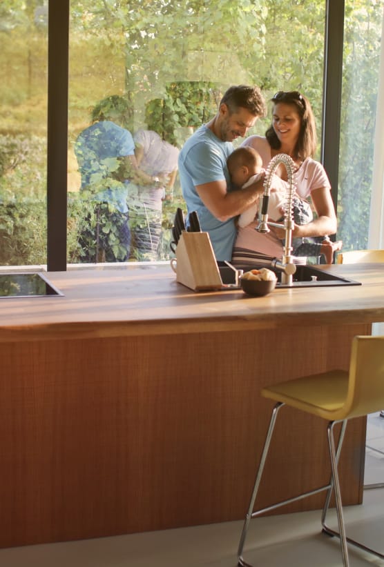 happy family in large kitchen with floor to ceiling windows