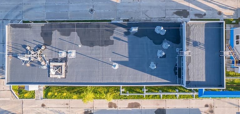 Aerial view of a flat industrial building roof with water damage