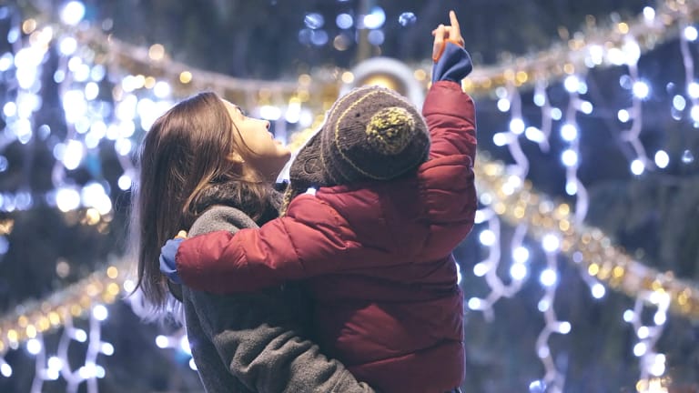 Mom and kid look at holiday lights