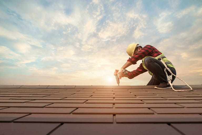 Roofer completing a roof replacement on a sunny Philadelphia day