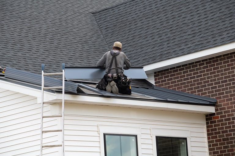 contractors repairs roof on smaller section of home
