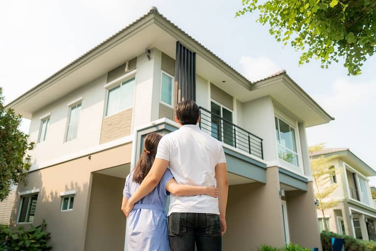 couple outside looking at their home