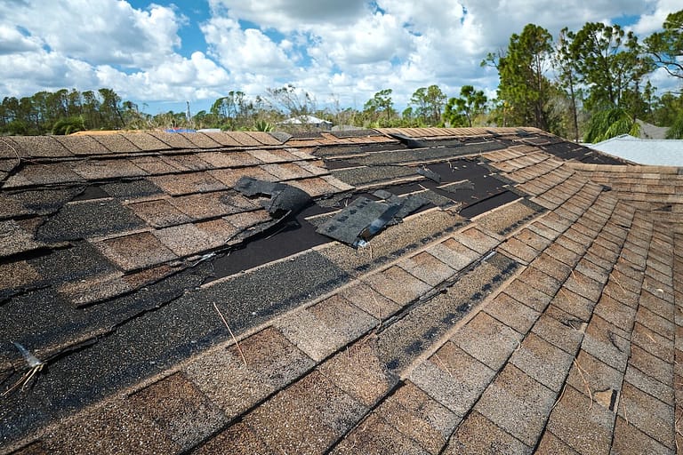Damaged house roof with missing shingles