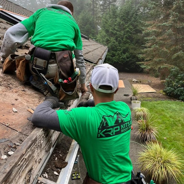 kitsap roof team fixing a damaged roof in green branded t-shirts
