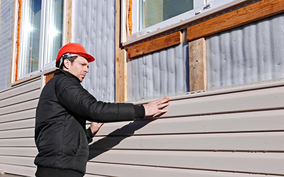 how long does vinyl siding last-man installing new vinyl siding on house