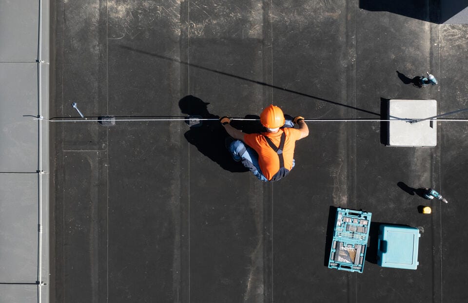 commercial roof replacement-aerial view of a roof tech installing new commercial roofing