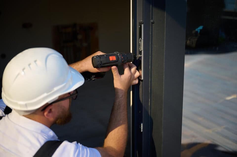 how to install an exterior door-close up of man using power tools to install an exterior door