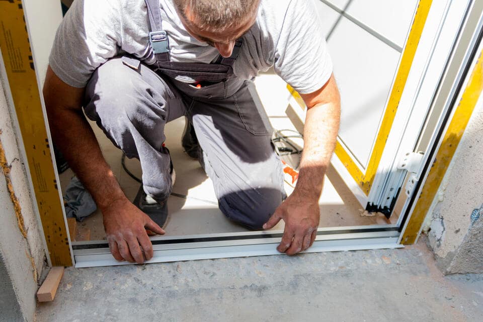 entry door installation-man installing the frame of a home's front door