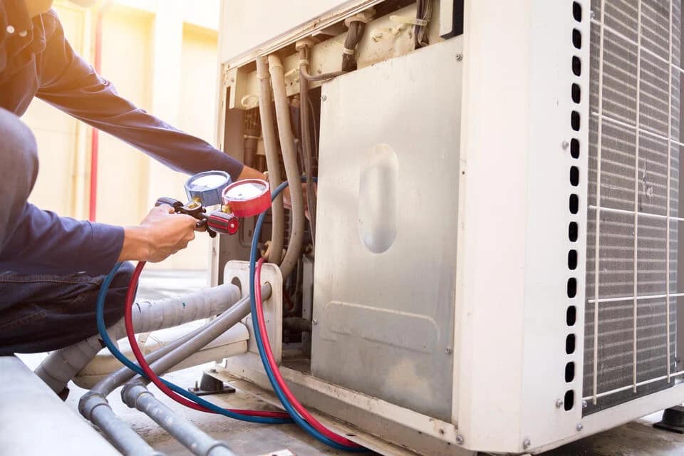 hvac-maintenance-cost-tech-using-equipment-to-perform-maintenance-on-an-ac-unit